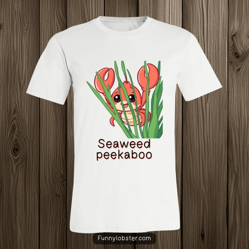 Funny t-shirt featuring a smiling lobster with comically large eyes, peering out from behind lush seaweed, full of playful mischief.
